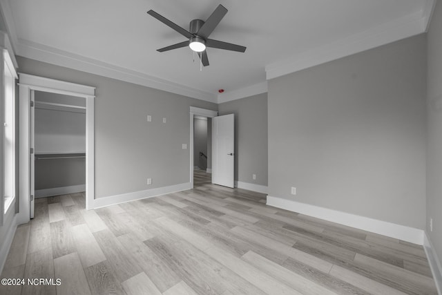 505 N Shore Dr, Sneads Ferry, NC 28460 - unfurnished bedroom featuring light wood finished floors, a spacious closet, baseboards, crown molding, and ceiling fan