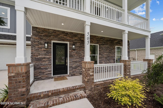 505 N Shore Dr, Sneads Ferry, NC 28460 - doorway to property featuring covered porch, stone siding, and a garage