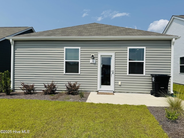 18 Landward Way, Wilmington, NC 28411 - back of house featuring roof with shingles, a lawn, and a patio area