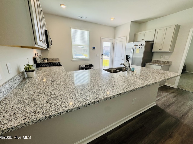 18 Landward Way, Wilmington, NC 28411 - kitchen with appliances with stainless steel finishes, a sink, dark wood-type flooring, light stone countertops, and a peninsula