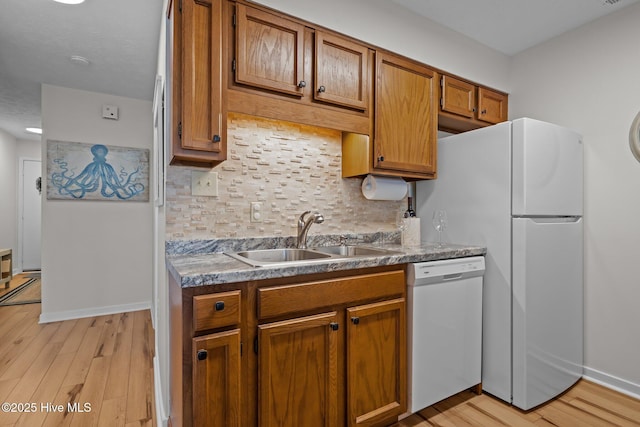 9100 Reed Dr Unit 3107, Emerald Isle, NC 28594 - kitchen with white appliances, a sink, tasteful backsplash, light wood finished floors, and brown cabinetry