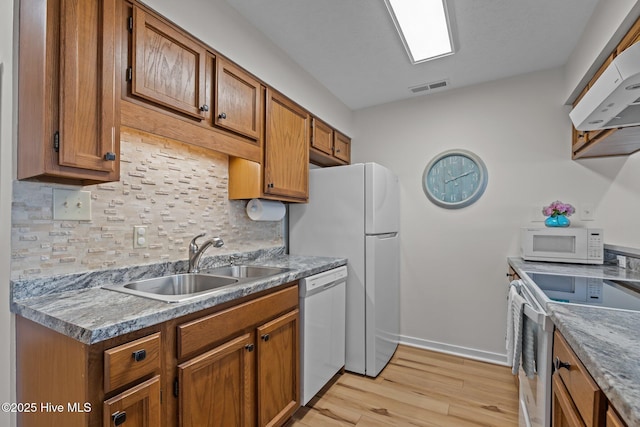 9100 Reed Dr Unit 3107, Emerald Isle, NC 28594 - kitchen with white appliances, a sink, tasteful backsplash, and brown cabinetry