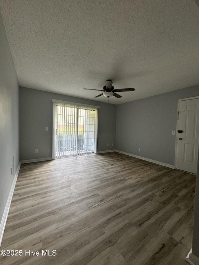 5633 Hornaday Rd Unit C, Greensboro, NC 27409 - unfurnished room with wood finished floors, a textured ceiling, a ceiling fan, and baseboards