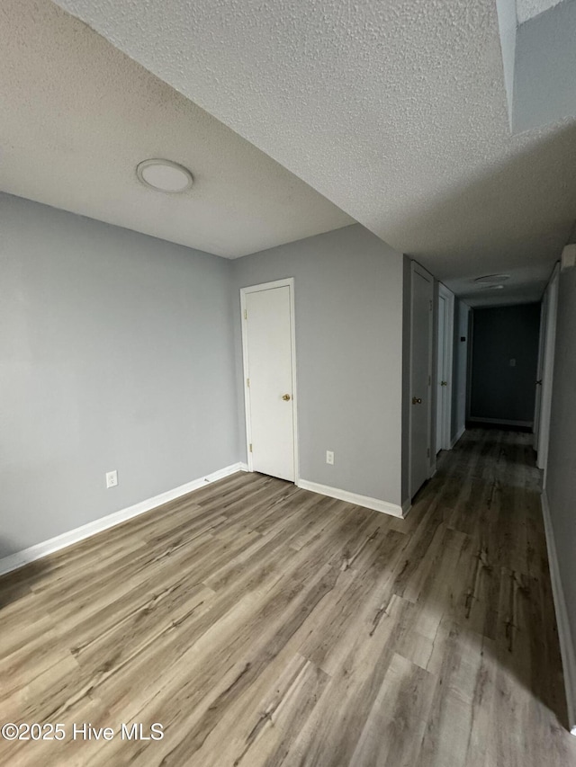 5633 Hornaday Rd Unit C, Greensboro, NC 27409 - spare room featuring wood finished floors, baseboards, and a textured ceiling