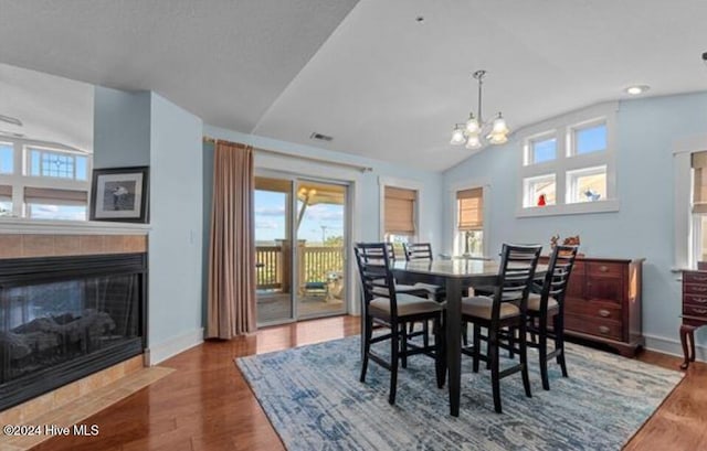 100 Mercedes Ct Unit F, Grandy, NC 27939 - dining area featuring lofted ceiling, healthy amount of natural light, a fireplace, and wood finished floors