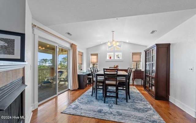 100 Mercedes Ct Unit F, Grandy, NC 27939 - dining space with a fireplace, vaulted ceiling, a chandelier, wood finished floors, and baseboards