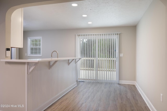 212 Tram Rd, West End, NC 27376 - kitchen with light wood finished floors, baseboards, a kitchen bar, recessed lighting, and arched walkways