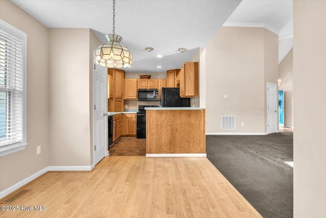 734 Sloop Pointe Ln, Kure Beach, NC 28449 - kitchen with black appliances, baseboards, light countertops, light wood-type flooring, and decorative backsplash