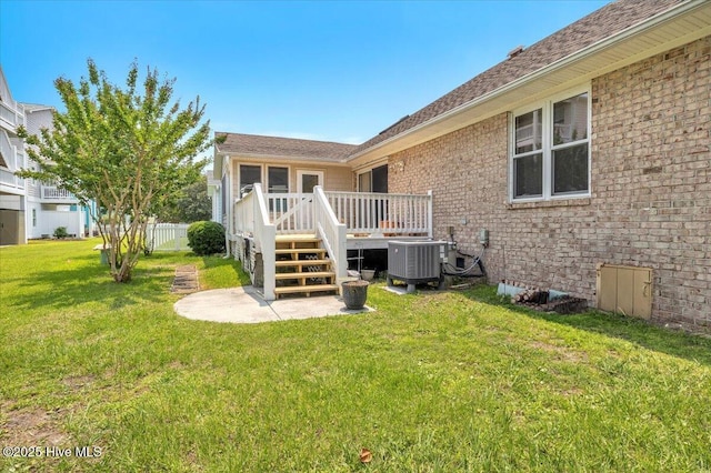 734 Sloop Pointe Ln, Kure Beach, NC 28449 - rear view of property with central AC unit, a wooden deck, brick siding, a patio area, and a shingled roof