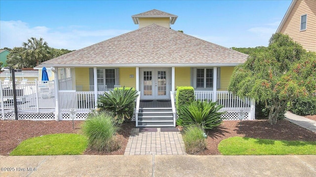 734 Sloop Pointe Ln, Kure Beach, NC 28449 - bungalow featuring a porch, roof with shingles, and french doors