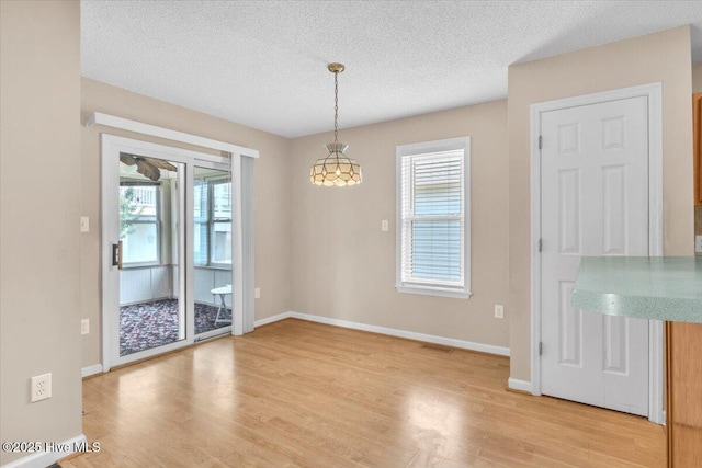 734 Sloop Pointe Ln, Kure Beach, NC 28449 - unfurnished dining area featuring light wood-style floors, a textured ceiling, and baseboards
