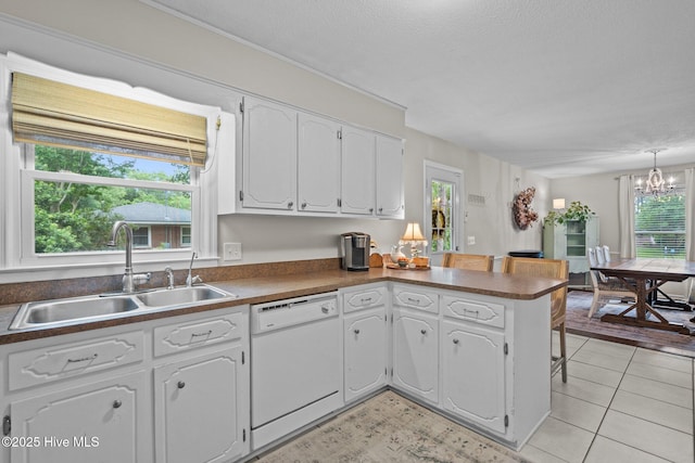 114 Mohican Trl, Wilmington, NC 28409 - kitchen featuring dishwasher, a sink, a peninsula, white cabinetry, and a chandelier