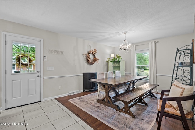114 Mohican Trl, Wilmington, NC 28409 - dining area featuring a chandelier, light tile patterned floors, baseboards, and a textured ceiling