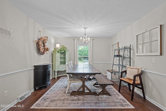 114 Mohican Trl, Wilmington, NC 28409 - dining space with a chandelier, baseboards, dark wood-type flooring, and a textured ceiling