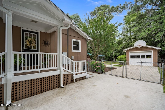 114 Mohican Trl, Wilmington, NC 28409 - property entrance featuring a detached garage, concrete driveway, and board and batten siding