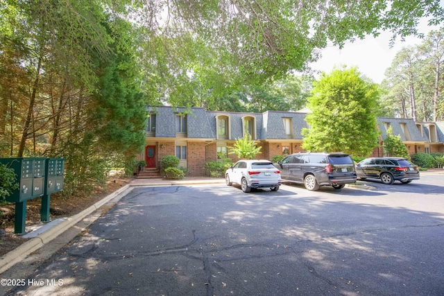 190 Palmetto Rd Unit 20, Pinehurst, NC 28374 - view of front of home featuring mansard roof, brick siding, a shingled roof, and uncovered parking