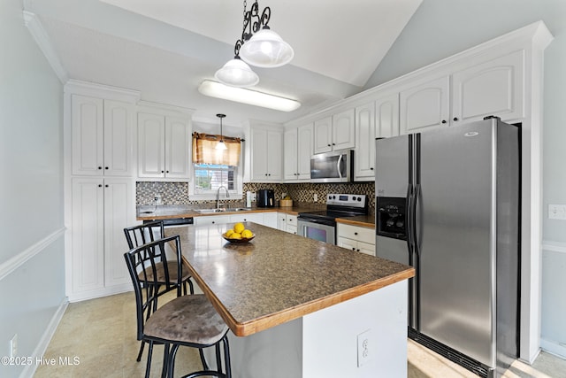 202 Brookside Way, Pikeville, NC 27863 - kitchen with stainless steel appliances, tasteful backsplash, white cabinets, dark countertops, and a kitchen bar