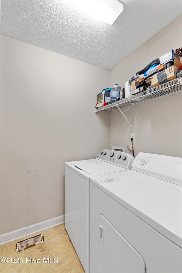 202 Brookside Way, Pikeville, NC 27863 - laundry room with washer and clothes dryer, baseboards, a textured ceiling, and light tile patterned flooring