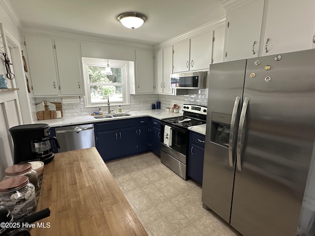 127 Deans Ln, Goldsboro, NC 27530 - kitchen with stainless steel appliances, a sink, decorative backsplash, blue cabinets, and ornamental molding