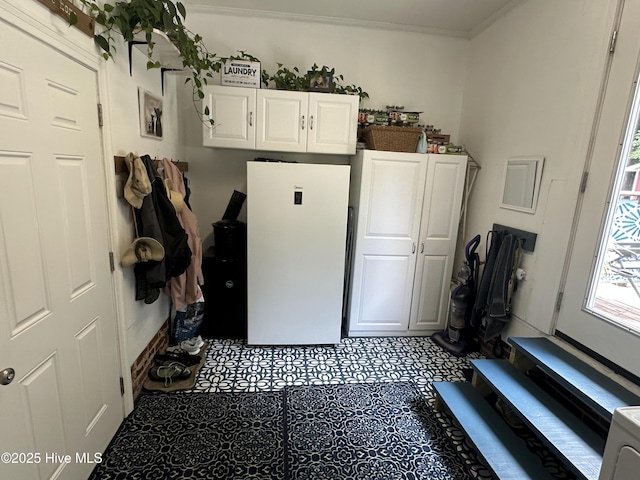127 Deans Ln, Goldsboro, NC 27530 - kitchen featuring white cabinetry, ornamental molding, and freestanding refrigerator