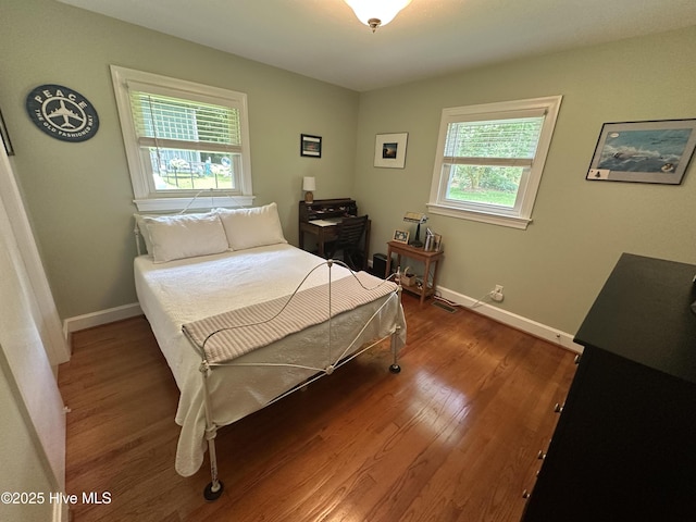 127 Deans Ln, Goldsboro, NC 27530 - bedroom with multiple windows, wood finished floors, and baseboards