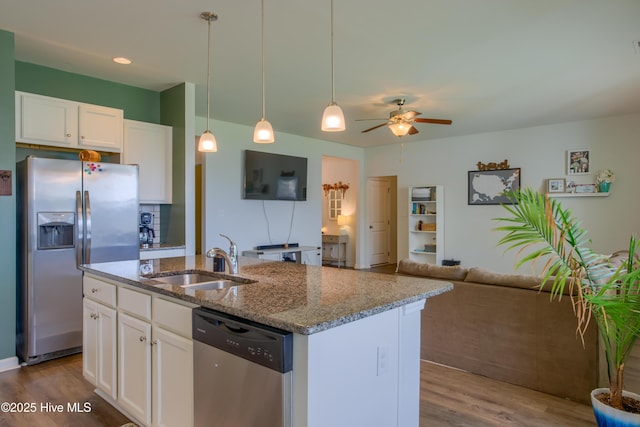 402 Saxby Way, Holly Ridge, NC 28445 - kitchen featuring appliances with stainless steel finishes, a sink, open floor plan, wood finished floors, and light stone countertops