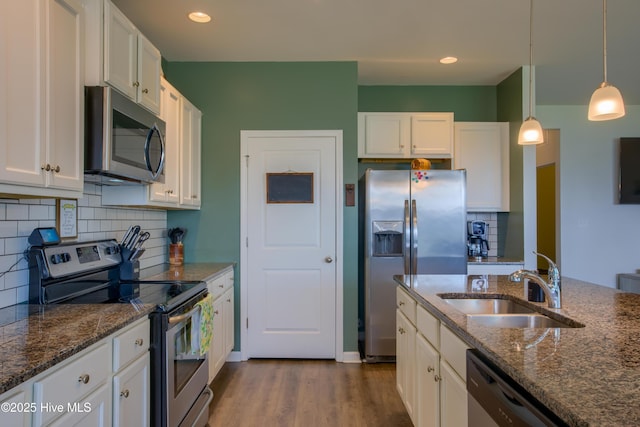 402 Saxby Way, Holly Ridge, NC 28445 - kitchen with stainless steel appliances, a sink, white cabinets, tasteful backsplash, and decorative light fixtures