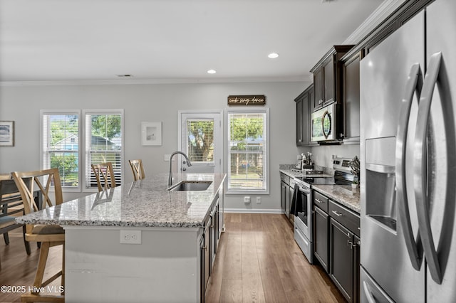 97 Violetear Rdg, Hampstead, NC 28443 - kitchen with stainless steel appliances, a sink, a center island with sink, a kitchen breakfast bar, and light stone counters