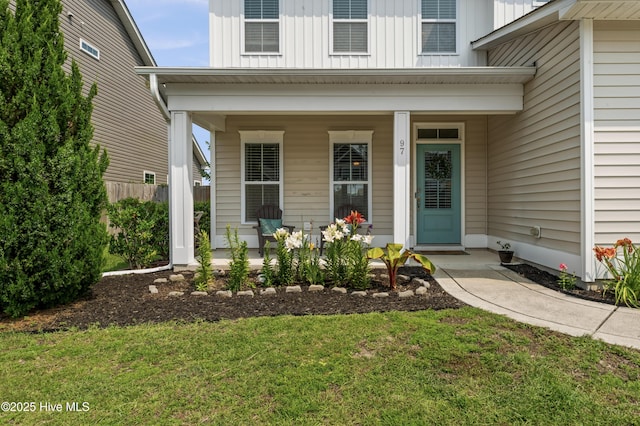 97 Violetear Rdg, Hampstead, NC 28443 - view of exterior entry with covered porch, board and batten siding, and a lawn