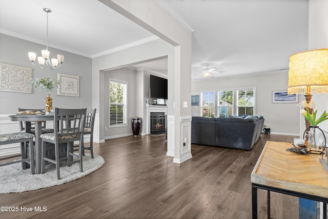 97 Violetear Rdg, Hampstead, NC 28443 - dining room with ornamental molding, dark wood finished floors, a chandelier, a ceiling fan, and a fireplace with flush hearth