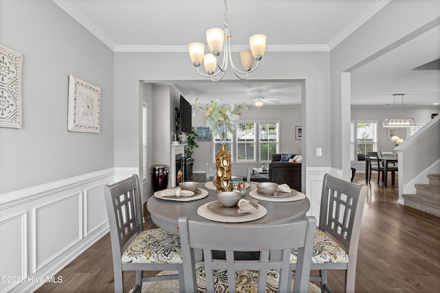 97 Violetear Rdg, Hampstead, NC 28443 - dining space with wood finished floors, a chandelier, a warm lit fireplace, plenty of natural light, and ornamental molding