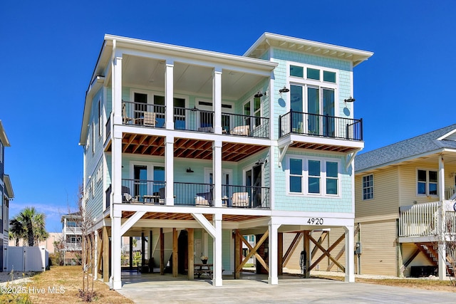 4920 E Beach Dr, Oak Island, NC 28465 - view of front of home featuring a carport, a balcony, and concrete driveway