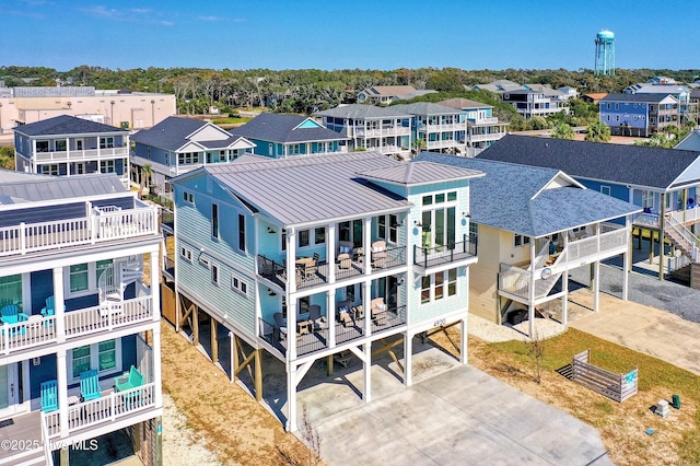 4920 E Beach Dr, Oak Island, NC 28465 - rear view of property featuring a standing seam roof, a residential view, a carport, metal roof, and driveway