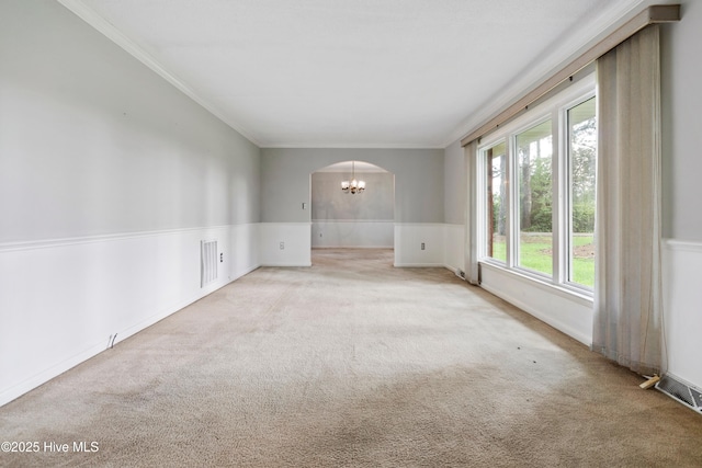 280 Cornwallis Rd, Teachey, NC 28464 - unfurnished room with crown molding, arched walkways, carpet, a wainscoted wall, and a chandelier