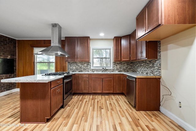 280 Cornwallis Rd, Teachey, NC 28464 - kitchen with island range hood, stainless steel appliances, a peninsula, light wood-type flooring, and backsplash