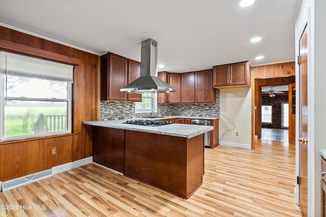 280 Cornwallis Rd, Teachey, NC 28464 - kitchen featuring island range hood, stainless steel dishwasher, a peninsula, light wood-style floors, and backsplash