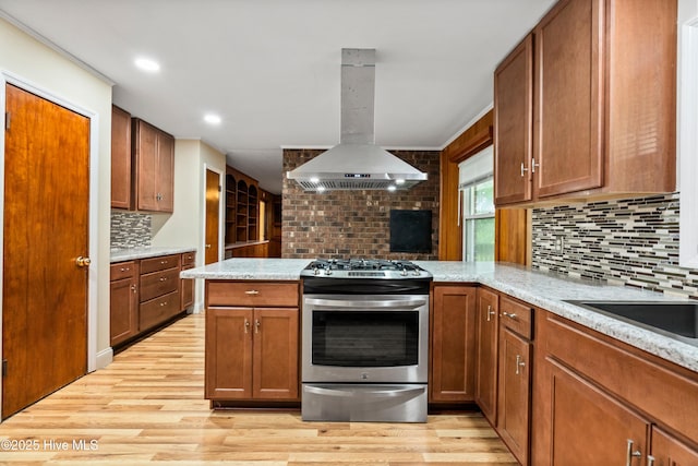 280 Cornwallis Rd, Teachey, NC 28464 - kitchen featuring stainless steel range with gas cooktop, island exhaust hood, a peninsula, decorative backsplash, and light wood-style flooring