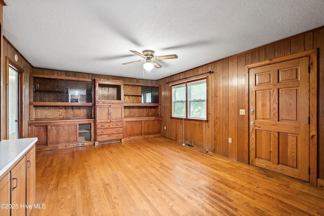 280 Cornwallis Rd, Teachey, NC 28464 - unfurnished living room with wooden walls, ceiling fan, a textured ceiling, and light wood finished floors