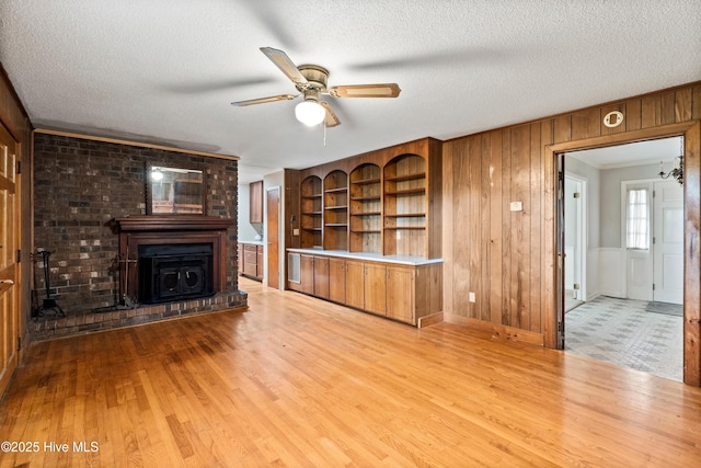 280 Cornwallis Rd, Teachey, NC 28464 - unfurnished living room with ceiling fan, wood finished floors, wooden walls, and a textured ceiling