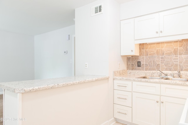 2525 Flint Dr, Wilmington, NC 28401 - kitchen with a sink, a peninsula, baseboards, and backsplash