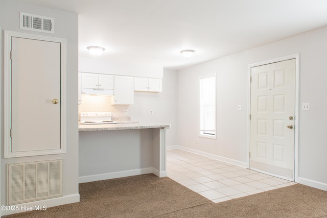 2525 Flint Dr, Wilmington, NC 28401 - kitchen with stove, light colored carpet, under cabinet range hood, white cabinetry, and light tile patterned flooring