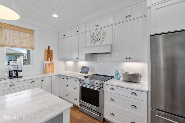 1044 Ocean Blvd W, Supply, NC 28462 - kitchen with appliances with stainless steel finishes, white cabinetry, tasteful backsplash, wood finished floors, and light stone counters