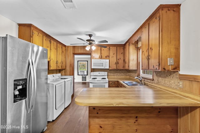 350 Toulon Dr, Wilmington, NC 28405 - kitchen with white appliances, washing machine and dryer, a peninsula, brown cabinets, and ceiling fan