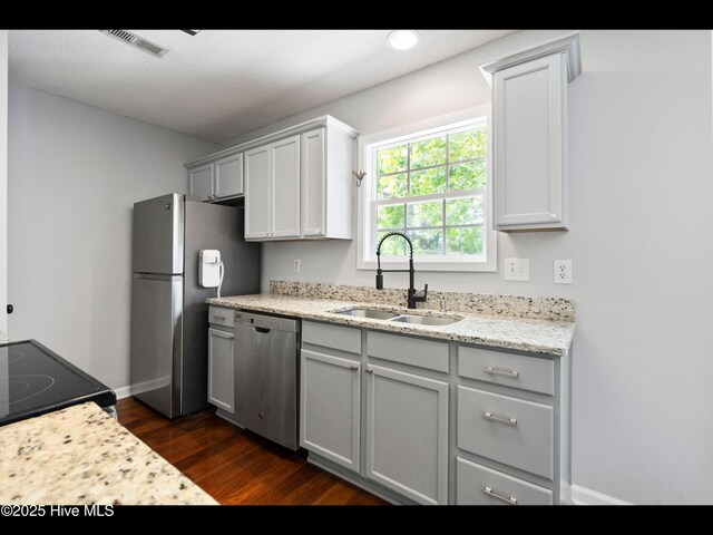 406 Endicott Ct, Wilmington, NC 28411 - kitchen featuring stainless steel appliances, a sink, dark wood-style flooring, baseboards, and light stone countertops
