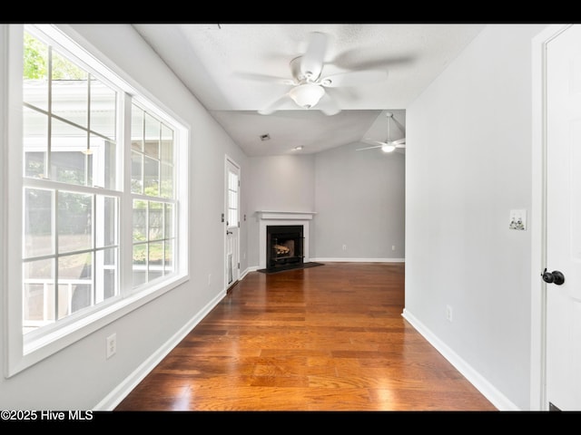 406 Endicott Ct, Wilmington, NC 28411 - unfurnished living room featuring a ceiling fan, wood finished floors, vaulted ceiling, baseboards, and a fireplace with flush hearth
