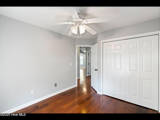 406 Endicott Ct, Wilmington, NC 28411 - unfurnished bedroom featuring dark wood-style floors, baseboards, a closet, and a ceiling fan