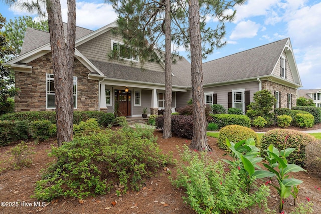 2584 Parkridge Dr, Southport, NC 28461 - view of front of house with a shingled roof, covered porch, and stone siding