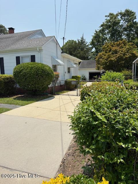 908 E 7th St, Lumberton, NC 28358 - view of home's exterior with a gate and a chimney
