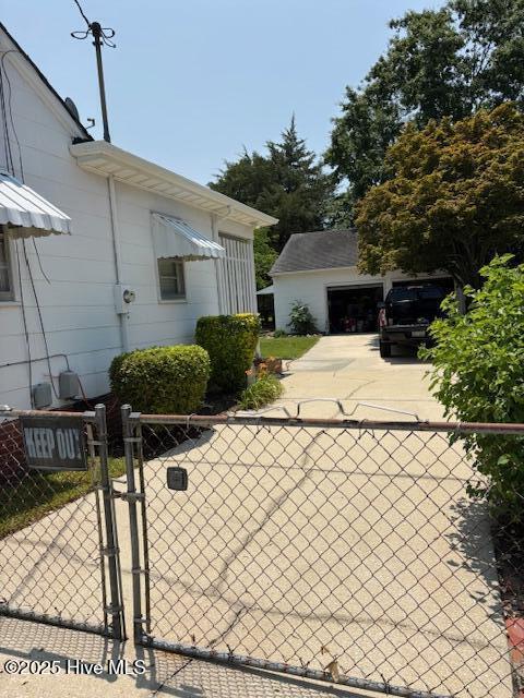 908 E 7th St, Lumberton, NC 28358 - view of side of property with driveway, a gate, and a garage