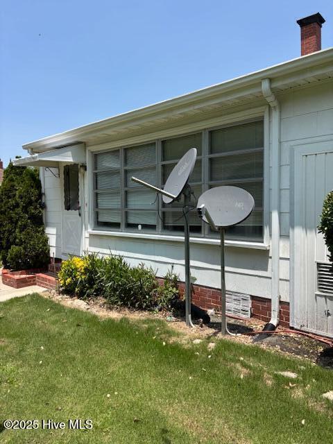 908 E 7th St, Lumberton, NC 28358 - view of side of property featuring a lawn and a chimney